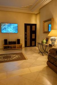 ein Wohnzimmer mit einem großen TV an der Wand in der Unterkunft Apartment Rue Kifa Meknes in Meknès