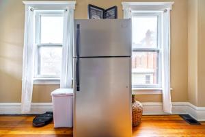 uma geladeira em uma sala com duas janelas em Jungle House Luxury Stays - Columbus Downtown Short North em Columbus mais 53 fotografias
