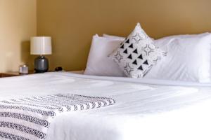 uma cama branca com lençóis brancos e almofadas em Jungle House Luxury Stays - Columbus Downtown Short North em Columbus