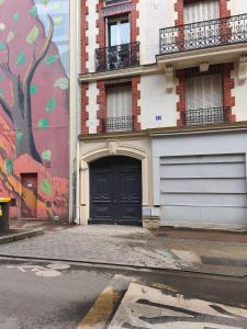 een gebouw met een zwarte deur en een muurschildering bij Cosy Hoche Saint Gervais in Pré Saint Gervais