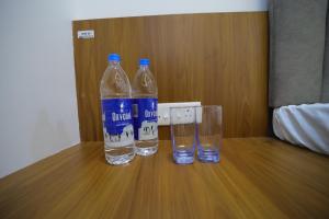 twee flessen water op een houten tafel bij Shivjanmabhumi Resort in Junnar