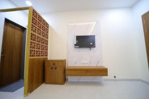 een woonkamer met een tv aan de muur bij Shivjanmabhumi Resort in Junnar