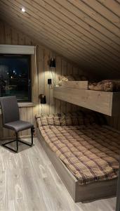 Un dormitorio con una litera y una silla. en Cosy cabin on Branäsberget - Illern 50, en Sysslebäck