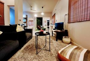 een woonkamer met een bank en een tafel bij Eden Green Nest in Bangalore