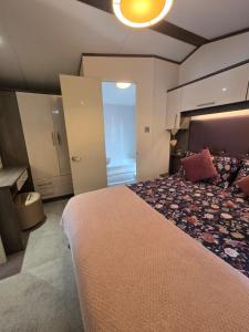 ein Schlafzimmer mit großem Bett und ein Badezimmer in der Unterkunft Rody's Cosy Corner in Crowle