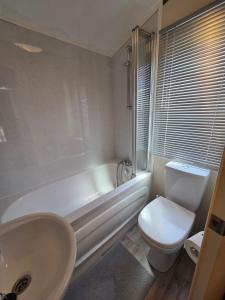 ein Badezimmer mit einer weißen Badewanne, einem WC und einem Waschbecken in der Unterkunft Rody's Cosy Corner in Crowle + 12 Fotos