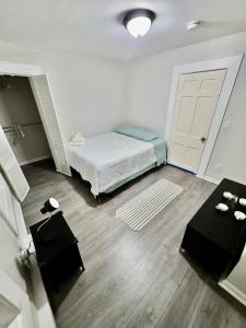 a bedroom with a bed and two black tables at Bright Private Room Shared Bathroom in Elizabeth