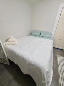 a bedroom with a bed with a white bedspread at Bright Private Room Shared Bathroom in Elizabeth