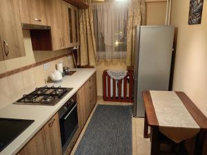 a small kitchen with a refrigerator and a table at Zielony Balkon in Sanok