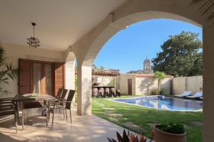 een terras met een tafel en stoelen en een zwembad bij Nicole Villa I "Free" Heated Pool, Village Escape in Embrósneros