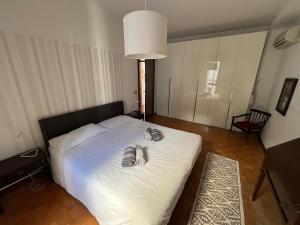 ein Schlafzimmer mit einem Bett mit einem Paar Hausschuhen darauf in der Unterkunft Luminoso appartamento in pieno centro città NUOVO! in Belluno