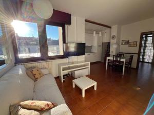 ein Wohnzimmer mit einer weißen Couch und einem Tisch in der Unterkunft Luminoso appartamento in pieno centro città NUOVO! in Belluno