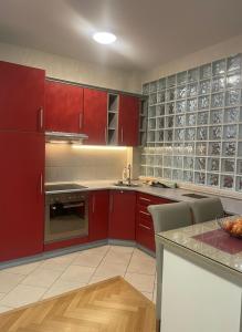 een keuken met rode kasten en een aanrecht bij FM Apartments ne qender te Pejes in Peje