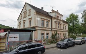 two cars parked in a parking lot in front of a building at Penzion Vejprty in Vejprty