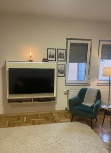 een woonkamer met een flatscreen-tv en een stoel bij FM Apartments ne qender te Pejes in Peje