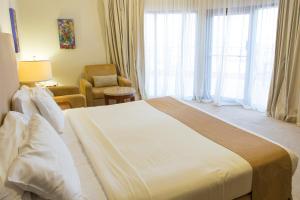 Ένα ή περισσότερα κρεβάτια σε δωμάτιο στο Al Qurum Resort