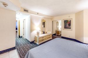 a bedroom with a bed and a dresser and a mirror at Daytona Beach Resort 533- Oceanfront Oasis in Daytona Beach +21 photos