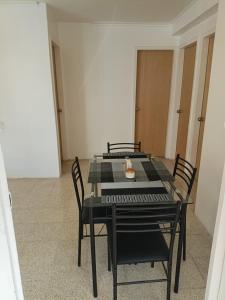 una mesa negra y sillas en una habitación en Apartamento Renovado a 5 Minutos del Centro Comercial Sambil Candelaria en Caracas, en Caracas
