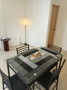 una mesa negra con dos sillas y un plato de comida. en Apartamento Renovado a 5 Minutos del Centro Comercial Sambil Candelaria en Caracas, en Caracas