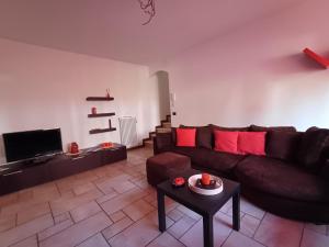 a living room with a brown couch and red pillows at Casina Rossa in Ballabio