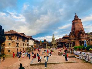 un grupo de personas caminando por una ciudad en Bhaktapur Yog Homestay, en Bhaktapur