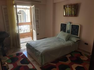 een slaapkamer met een bed in een kamer met een deur bij Apartment Alexandria City Center in Alexandrië