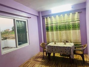Un comedor con una mesa y una ventana. en Bhaktapur Yog Homestay, en Bhaktapur