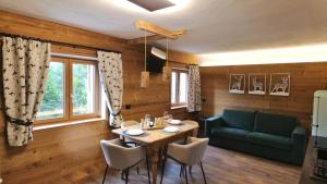 a dining room with a table and a green couch at Chalet Peter in Folgaria