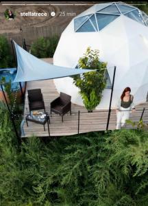 a woman sitting on a deck with an umbrella at Nyxia Dome in Caravaca de la Cruz
