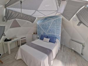 a bedroom with a large bed with blue pillows at Nyxia Dome in Caravaca de la Cruz
