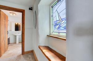 a bathroom with a stained glass window and a sink at 4 Bed in Looe oc-l30047 in Looe +14 photos