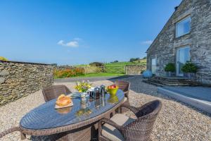 un patio con mesa y sillas y un edificio de piedra en 2 Bed in Middleton oc-h29514, en Middleton