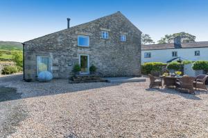 Una casa de piedra con una mesa y sillas delante de ella. en 2 Bed in Middleton oc-h29514, en Middleton