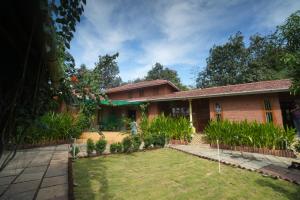 a house with a garden in front of it at Green Roots Farm Stay, Shahapur in Shāhāpur