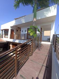 una casa con una recinzione e una palma di Quarto Duplo com Ar e Banheiro Privativo a poucos metros do mar a Porto De Galinhas