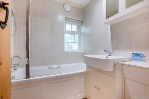 a white bathroom with a sink and a shower at 2 Bed in Looe oc-l30015 in Lansallos +12 photos