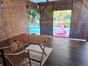 a room with a table and a pink swan in the window at 1 Bedroom Apartment on ground floor with access to swimming pool in Rose Hill