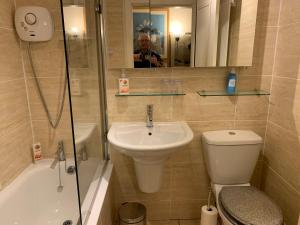 een badkamer met een wastafel, een toilet en een douche bij Geraldsplace in Edinburgh