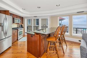 eine Küche mit einer Theke mit Stühlen und einem Kühlschrank in der Unterkunft Shiphouse 2 - Second Floor in East End