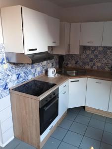 cocina con armarios blancos y fogones negros en Chalet Sedmihori, en Staré Sedlo