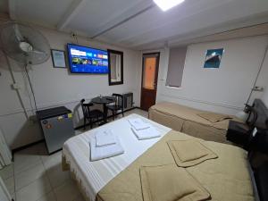 a hotel room with two beds and a flat screen tv at Hosteria Marina Bella 2 in Rada Tilly