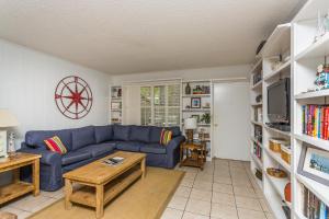 ein Wohnzimmer mit einem blauen Sofa und einem Tisch in der Unterkunft 510 A Magnolia in Ebo Landing