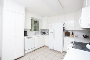 eine weiße Küche mit weißen Schränken und einem Kühlschrank in der Unterkunft 510 A Magnolia in Ebo Landing + 12 Fotos