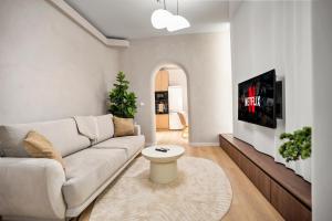 un soggiorno con un divano e una TV di Central Designer Condo a Bucarest