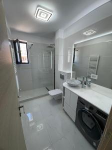 een badkamer met toilet, wastafel en wasmachine bij Sarah Apartment in Constanţa