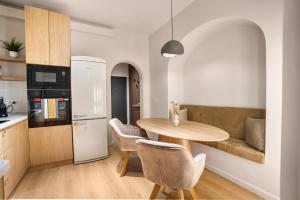 una cucina e una sala da pranzo con tavolo e sedie in legno di Central Designer Condo a Bucarest