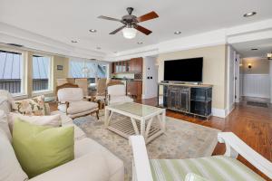 a living room with a white couch and a tv at Shiphouse 3 - Third Floor in Saint Simons
