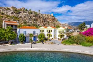 a row of houses in front of a mountain at Mandraki Paradise in Meyisti