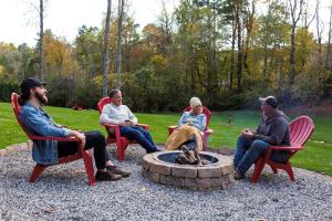 a group of people sitting around a fire pit at The Maple Cottage in Asheville