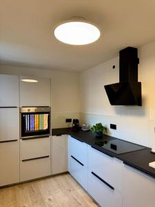 een keuken met witte kasten en een zwart aanrechtblad bij Ferienwohnung No 5`2 Rottweil in Rottweil +10 foto's